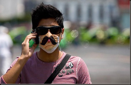 A man wears a decorated protective mask as he talks on his cell phone in downtown Mexico City, Monday, April 27, 2009.  A fatal strain of swine flu has been detected in Mexico while the virus has been confirmed or suspected in at least a half-dozen other countries.  (AP Photo/Eduardo Verdugo)
